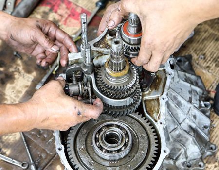 A group of people are working on a gearbox.