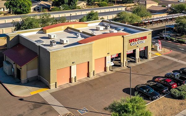 An aerial view of a car wash with cars parked in front of it.