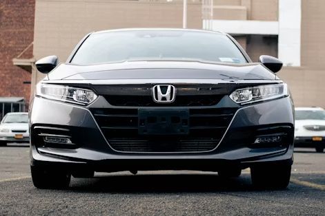 Front view of a black Honda sedan parked in front of a building