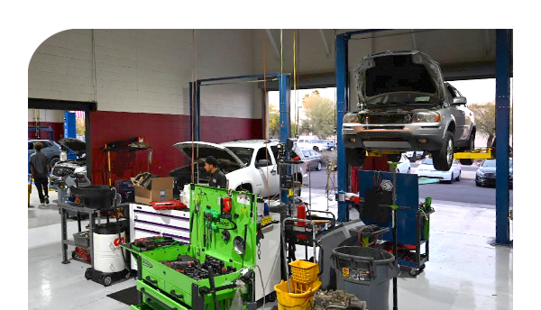 A car is sitting on a lift in a garage.