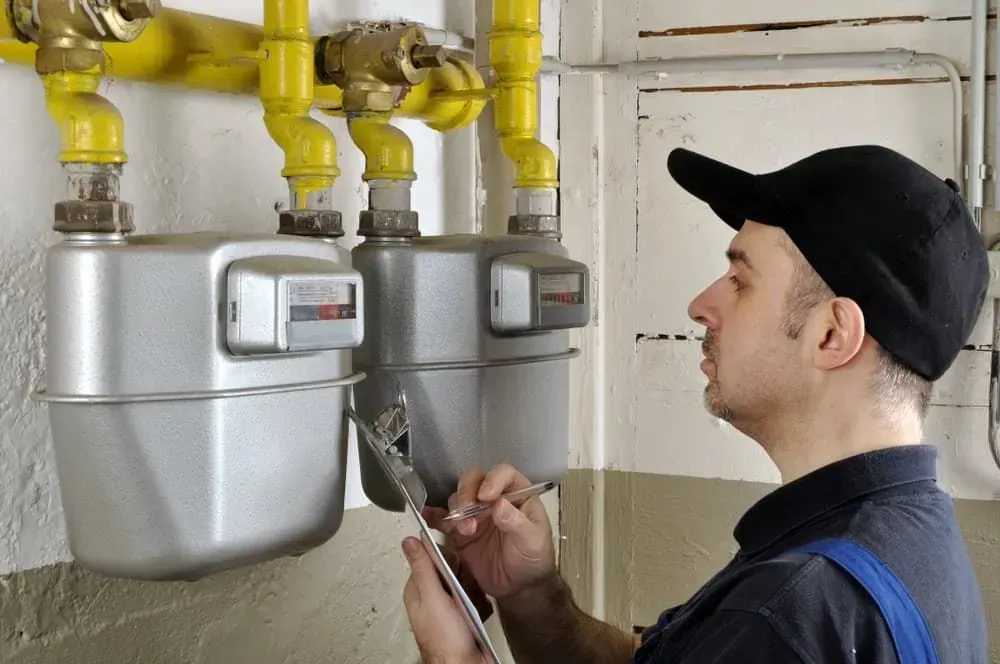 A Man Is Working on A Gas Meter with A Wrench — Medowie Plumbing & Gas In Medowie, NSW