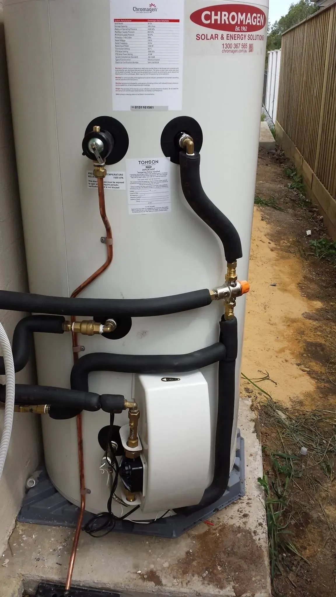 A White Water Heater with Black Pipes Attached to It — Medowie Plumbing & Gas In Medowie, NSW