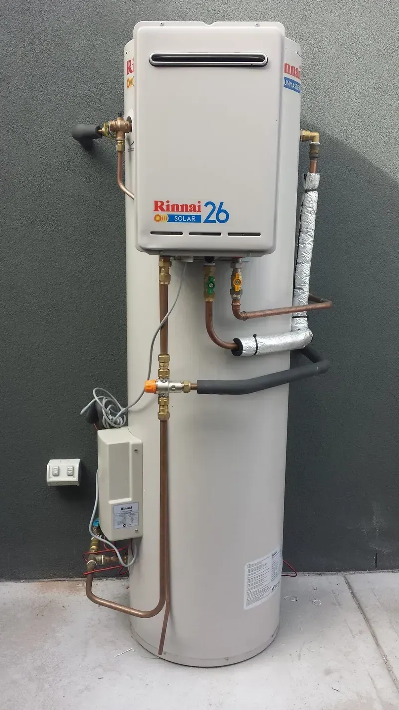 A Water Heater Is Sitting on The Sidewalk Next to A Wall — Medowie Plumbing & Gas In Medowie, NSW
