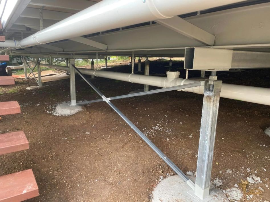 A White Pipe Is Hanging from a Building — Medowie Plumbing & Gas In Medowie, NSW