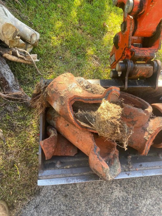 A Pile of Clay Pots in A Bucket on The Ground — Medowie Plumbing & Gas In Medowie, NSW