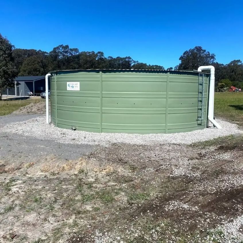 A Green Water Tank with A White Pipe Attached to It — Medowie Plumbing & Gas In Medowie, NSW