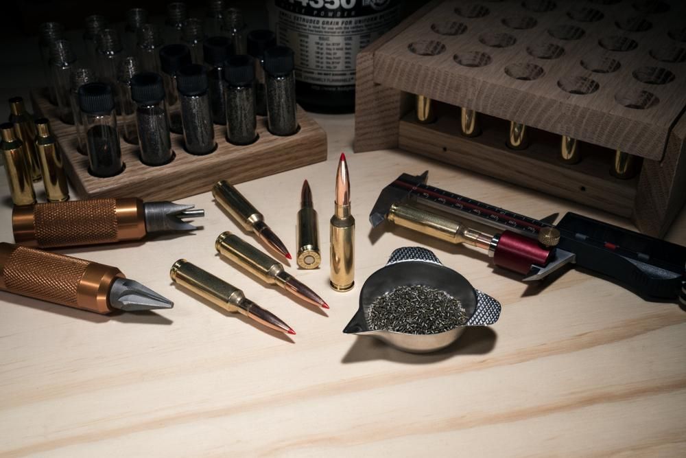 A Wooden Table Topped With a Variety of Bullets and Tools — Coffs Coast Firearms In Coffs Harbour, NSW