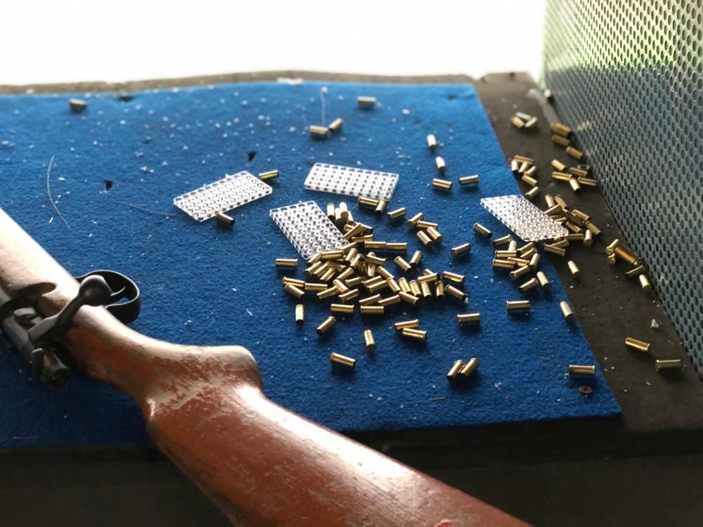 A Rifle and Several Bullets Are Displayed on a Blue Mat — Coffs Coast Firearms In Coffs Harbour, NSW