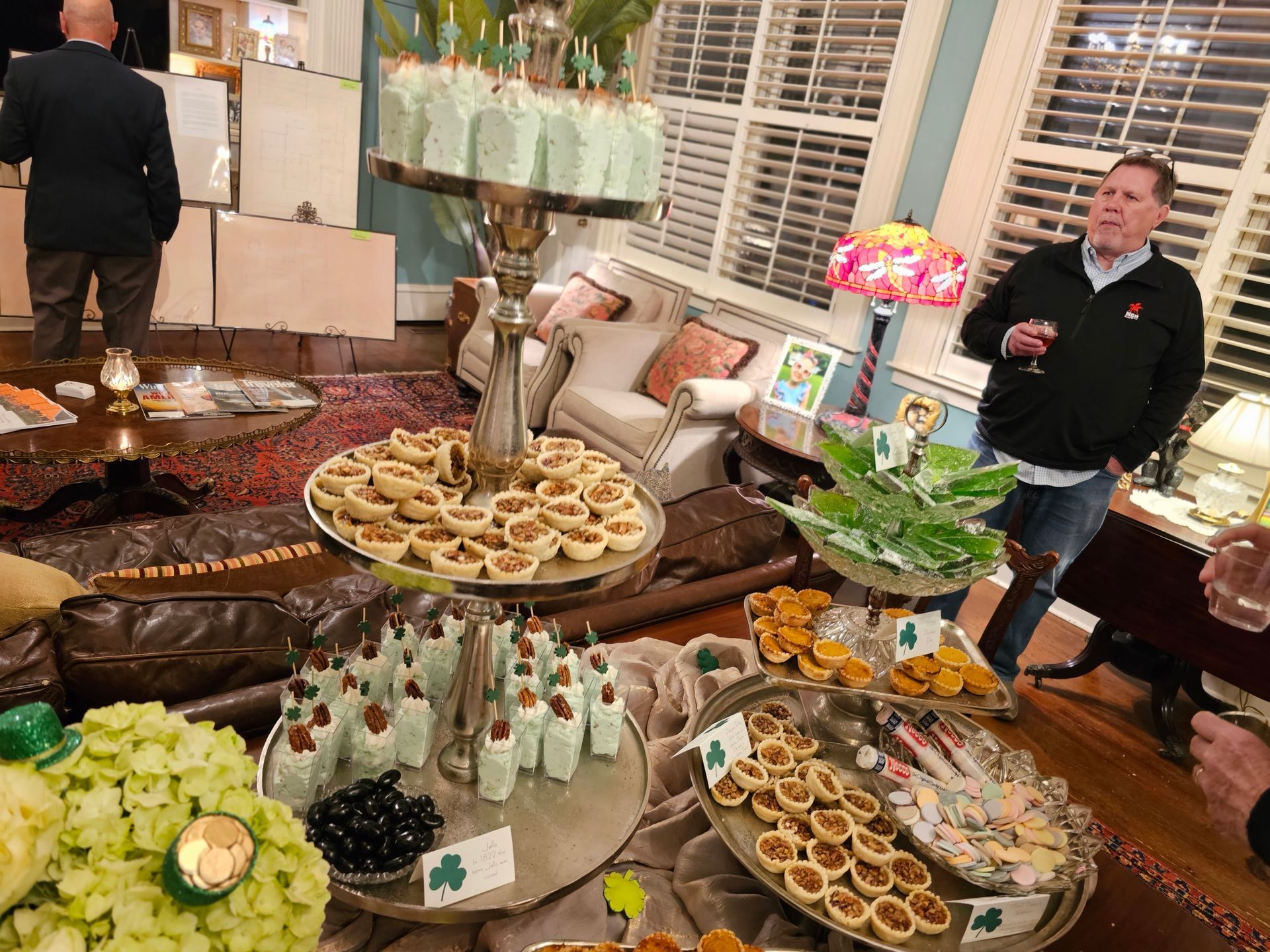 A group of people are standing around a table filled with food.