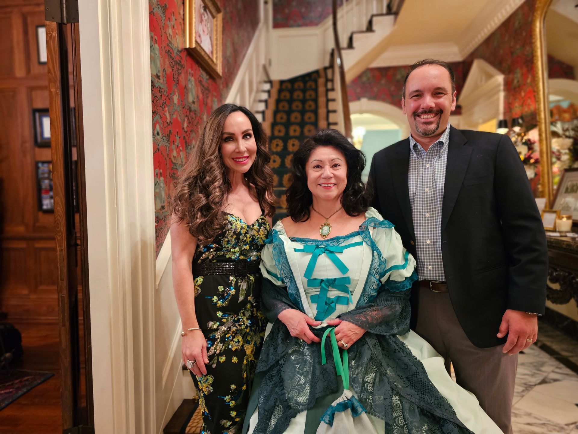 A man and two women are posing for a picture in a hallway.