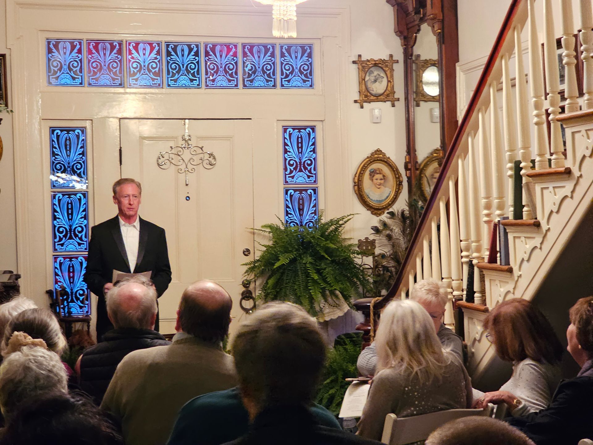 A man in a suit stands in front of a crowd of people