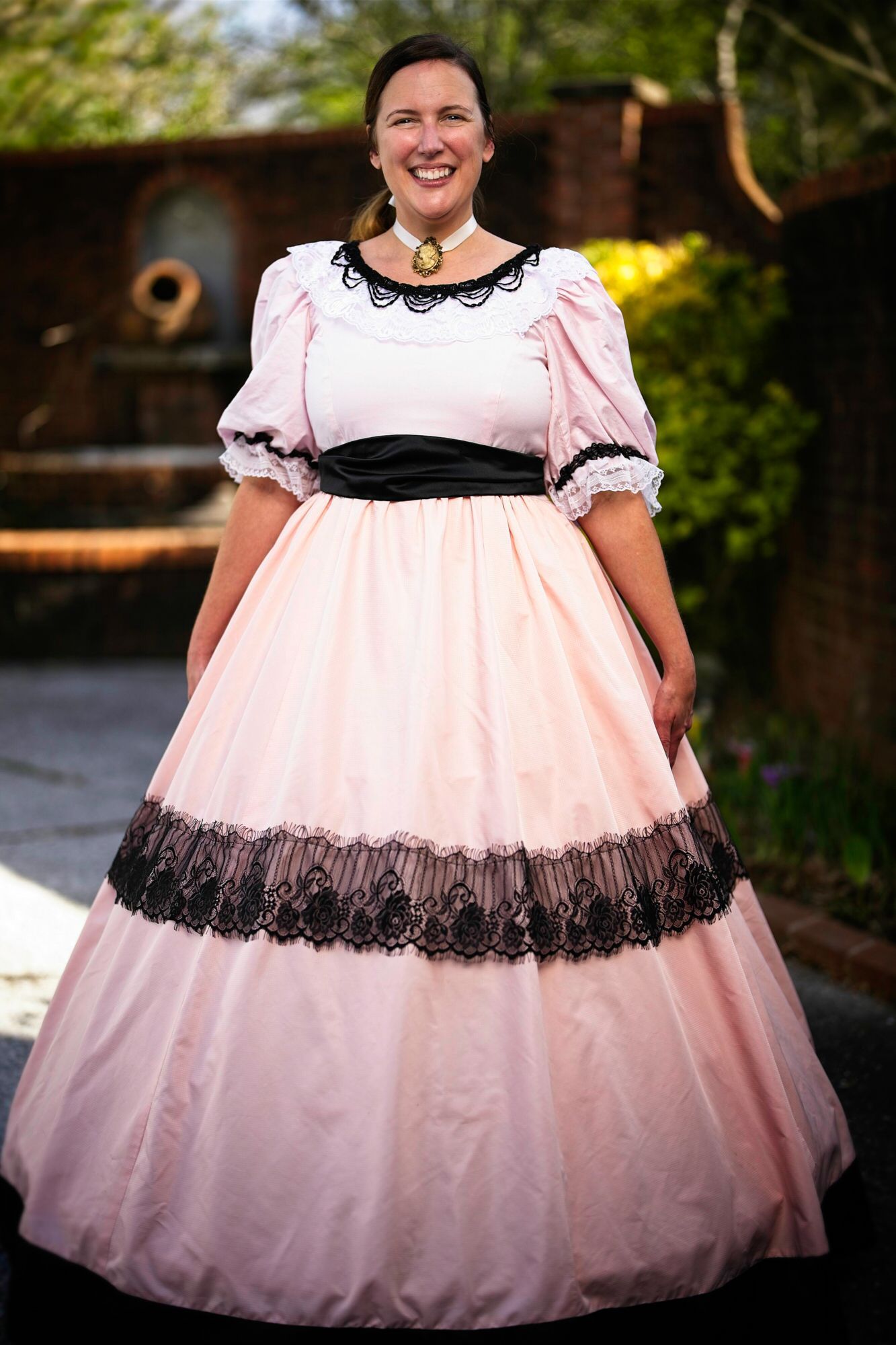 A woman in a pink and black dress is smiling