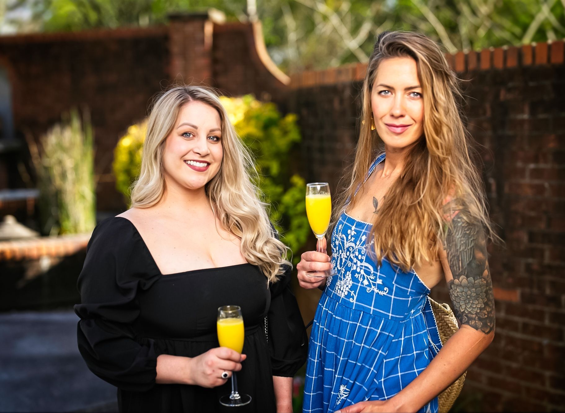 Two women are standing next to each other holding glasses of champagne.