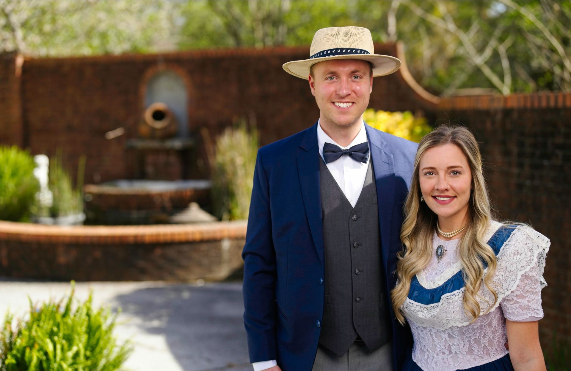 A man and a woman are posing for a picture in front of a fountain.