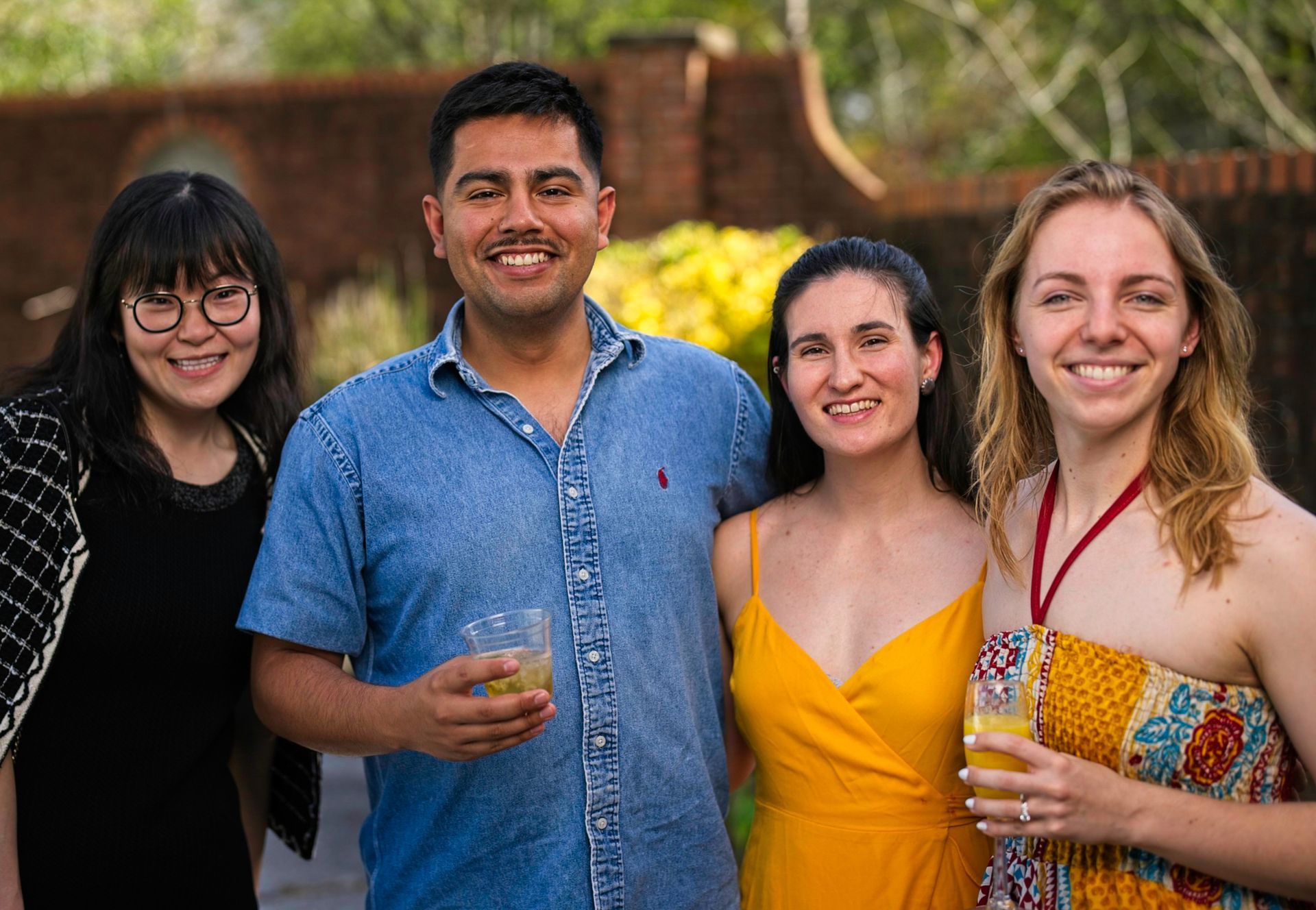 A group of people are posing for a picture together while holding drinks.