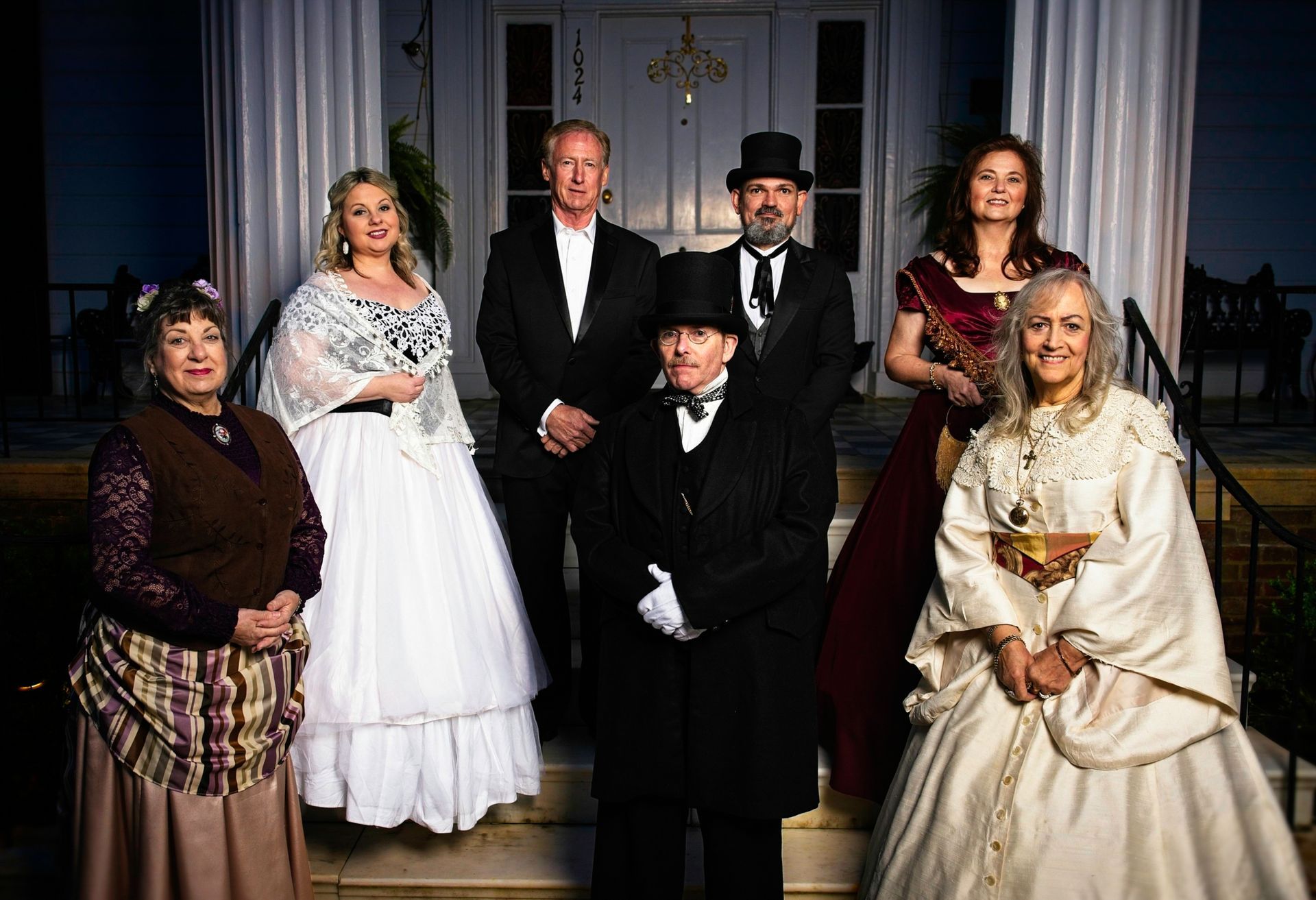 A group of people dressed in historical costumes are posing for a picture.