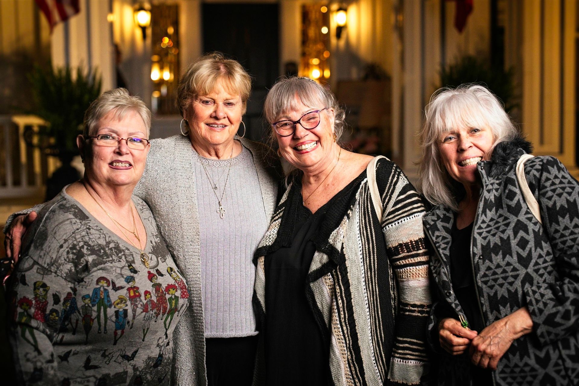 A group of four older women are posing for a picture together.