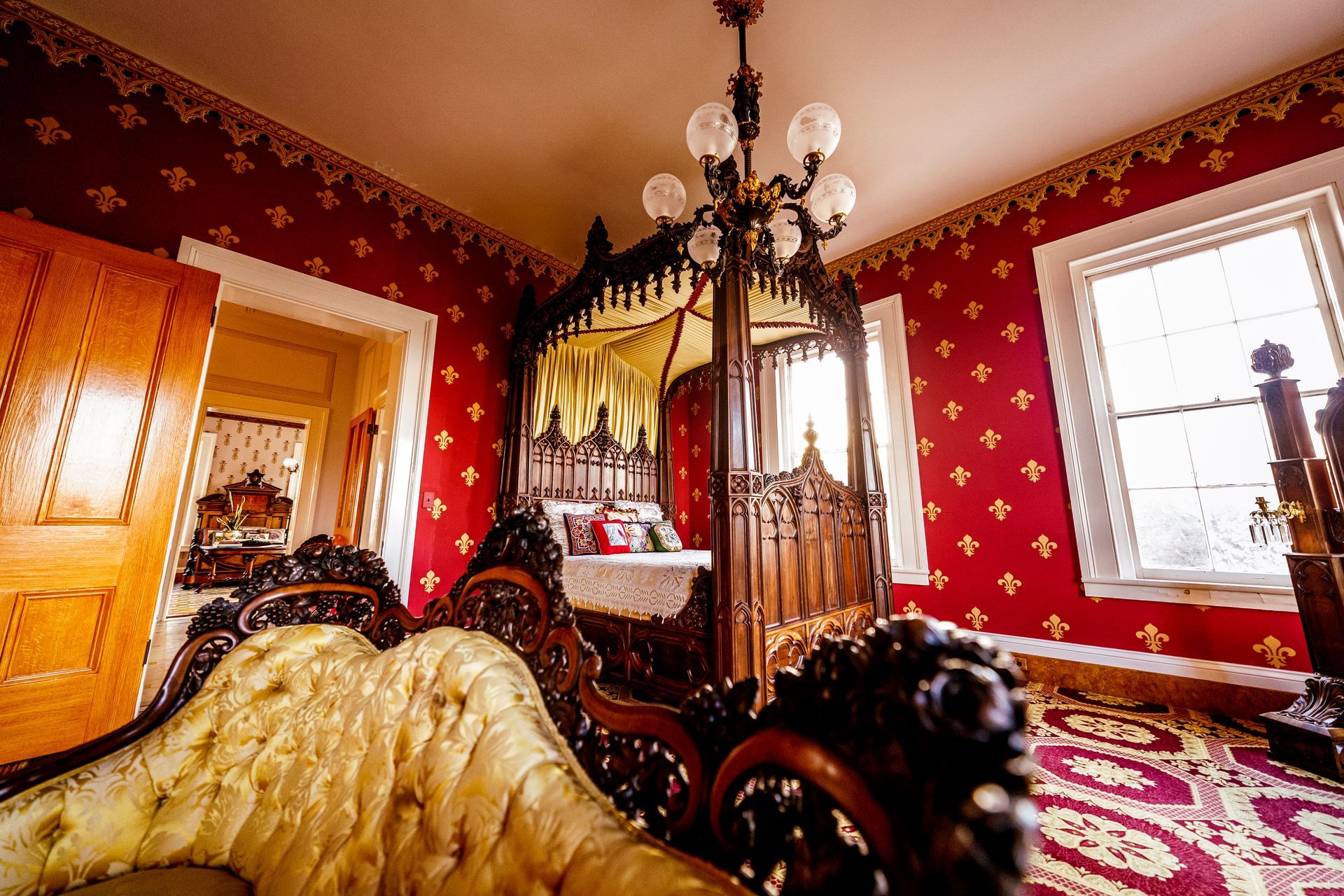 A bedroom with a canopy bed and a couch.