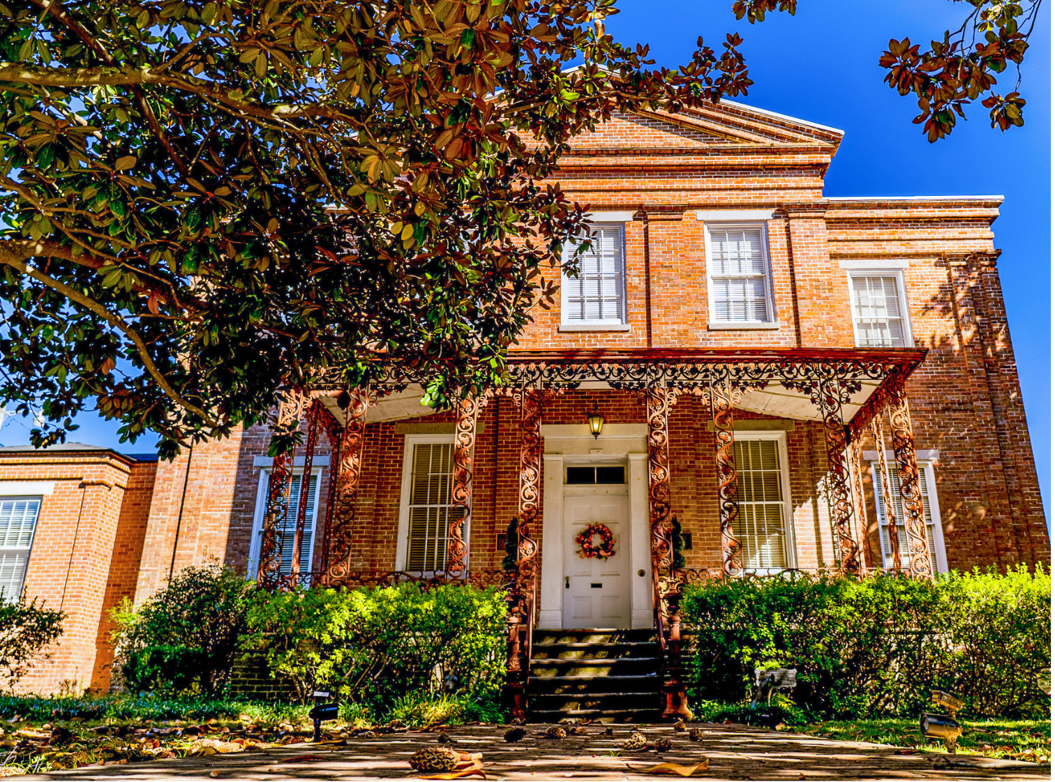 A large brick house with a tree in front of it