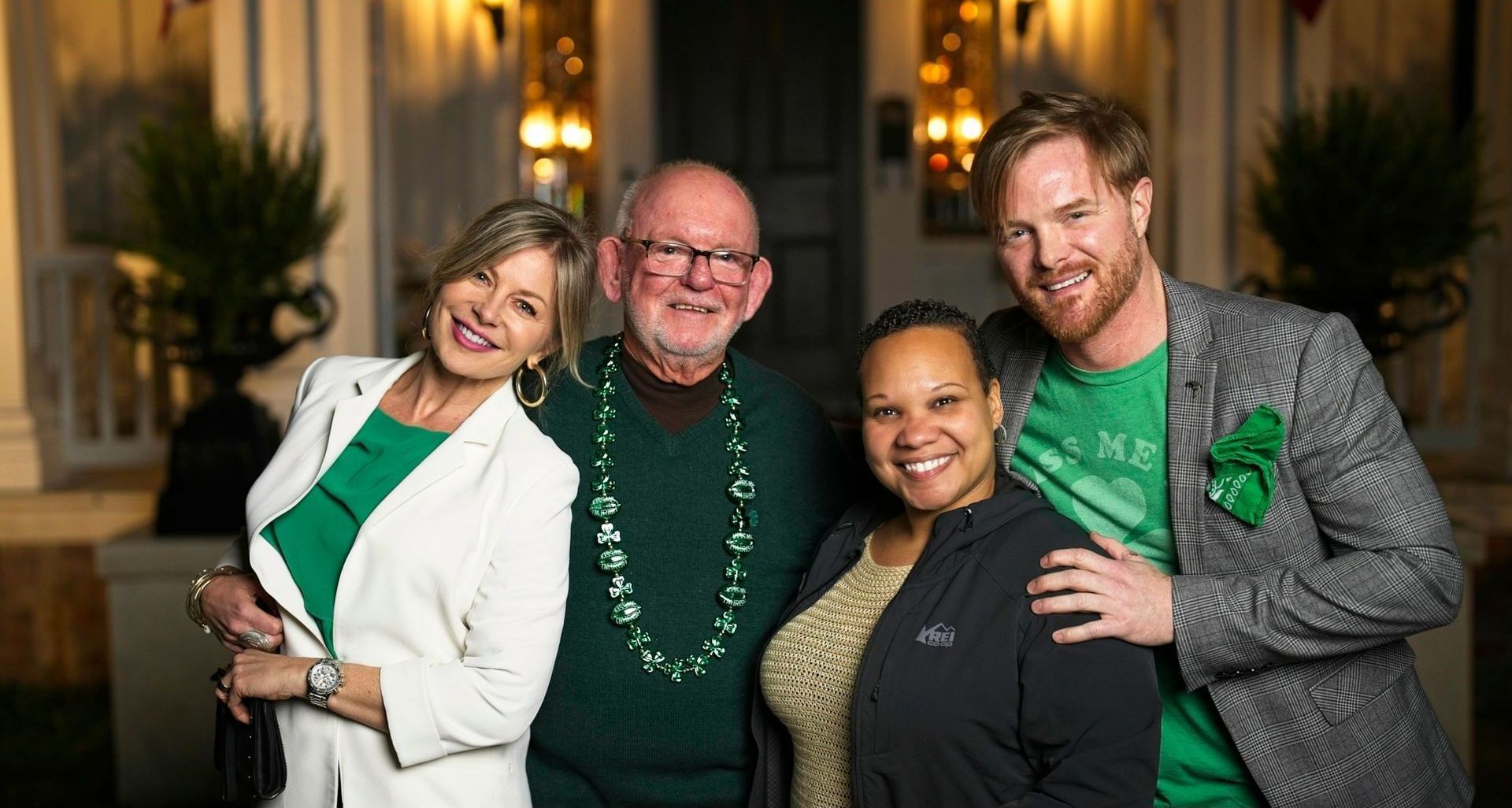 A group of people are posing for a picture in front of a house.