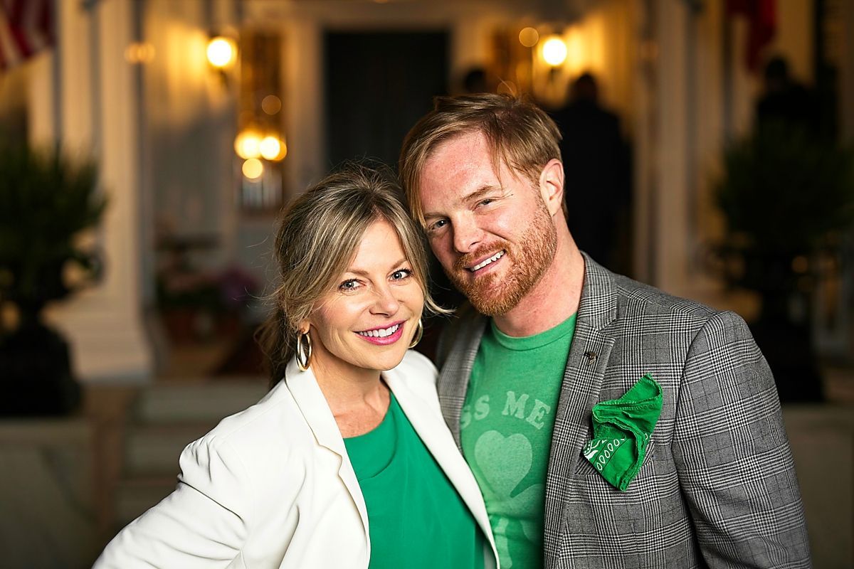 A man and a woman are posing for a picture in front of a building.