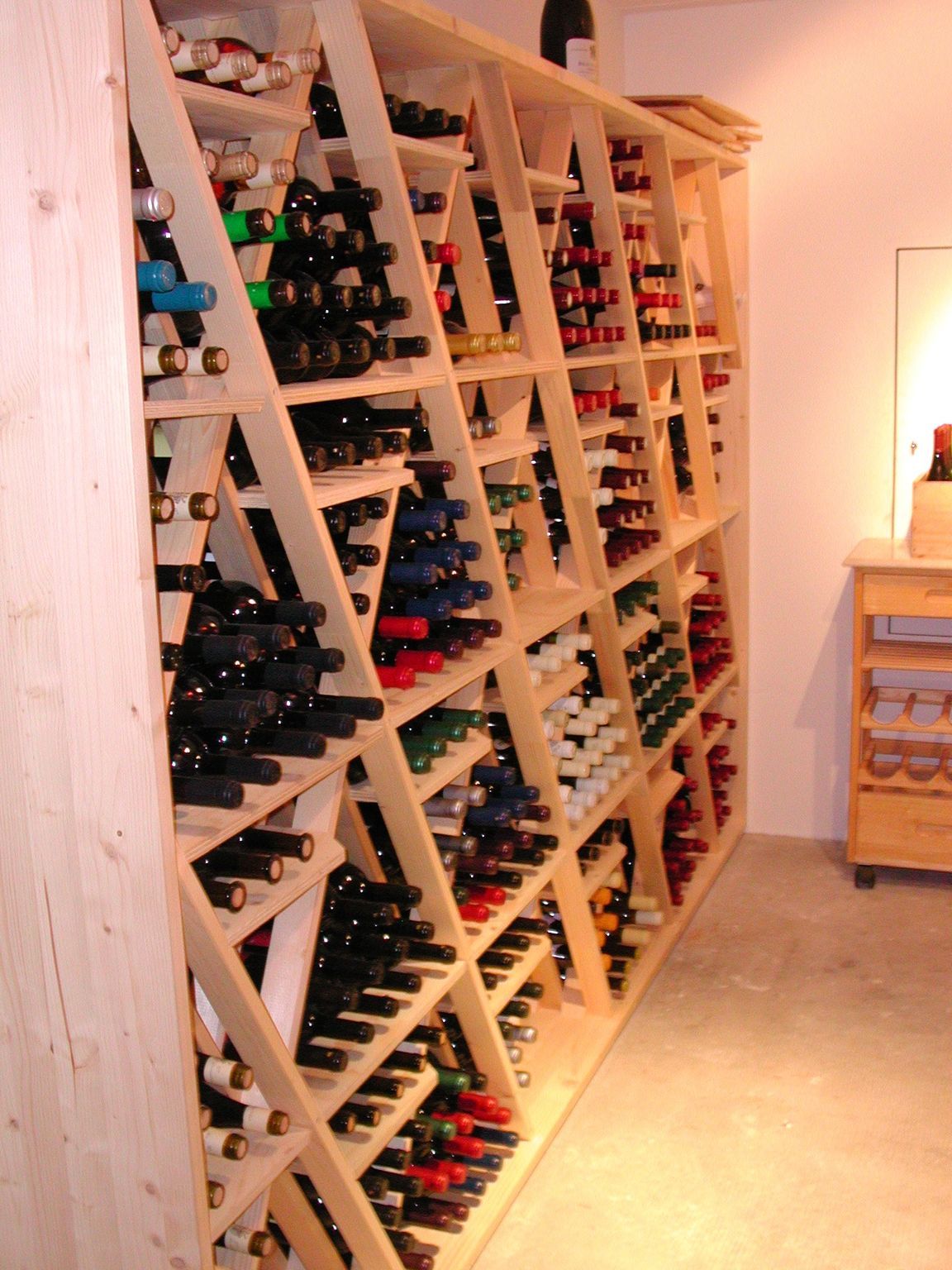 Casier à vin en bois rempli de diverses bouteilles de vin, décor intérieur.