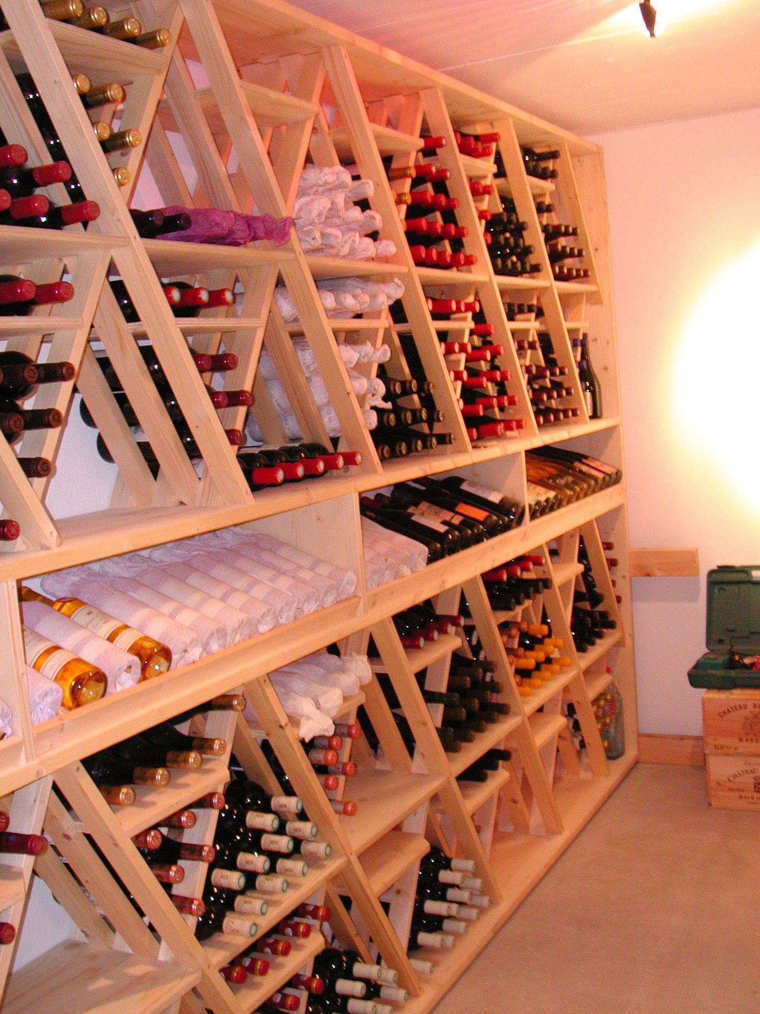 Casier à vin en bois rempli de bouteilles dans une cave à domicile.