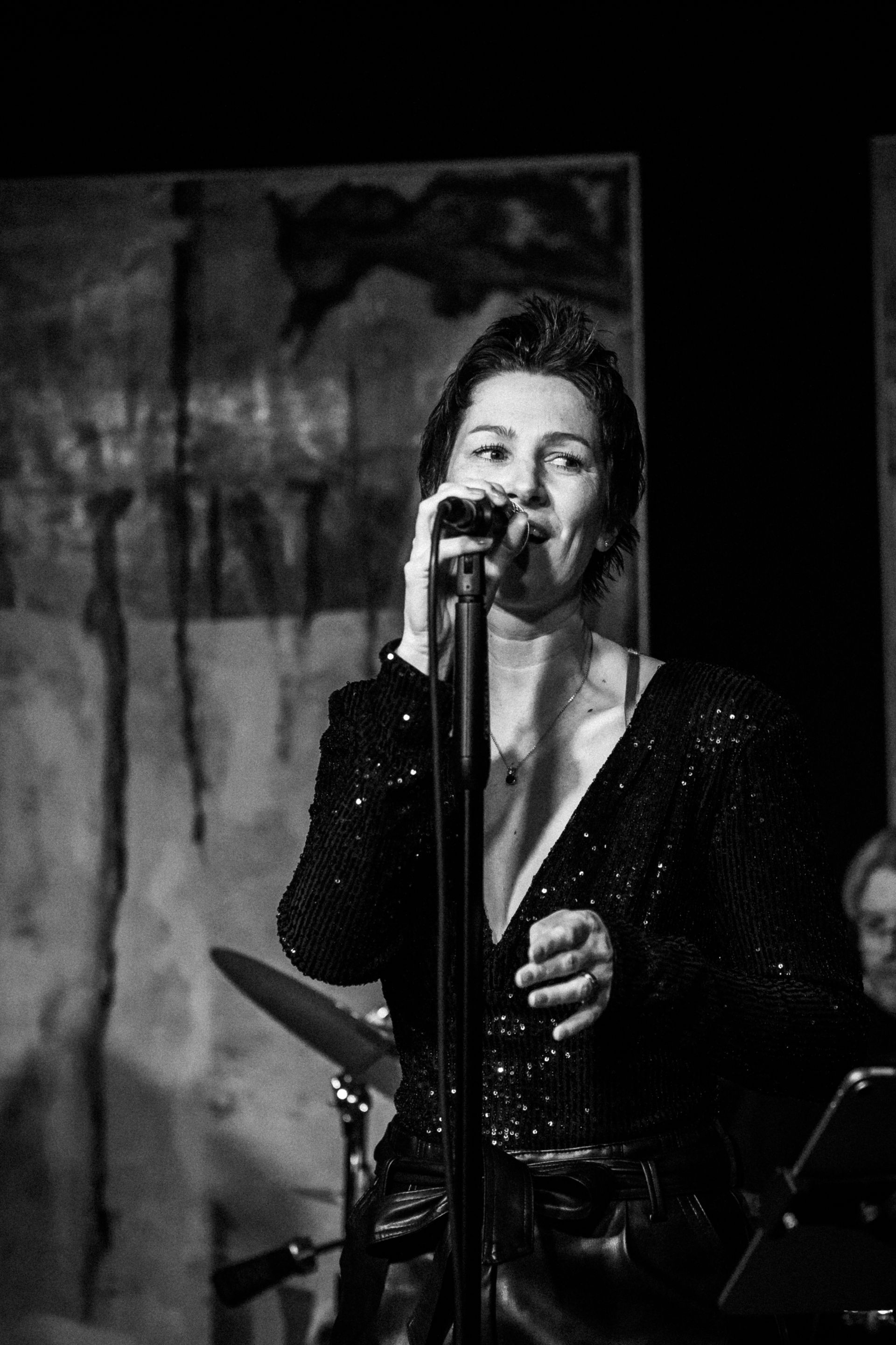 Auf einem Schwarz-Weiß-Foto singt Natalia Salamin in ein Mikrofon.