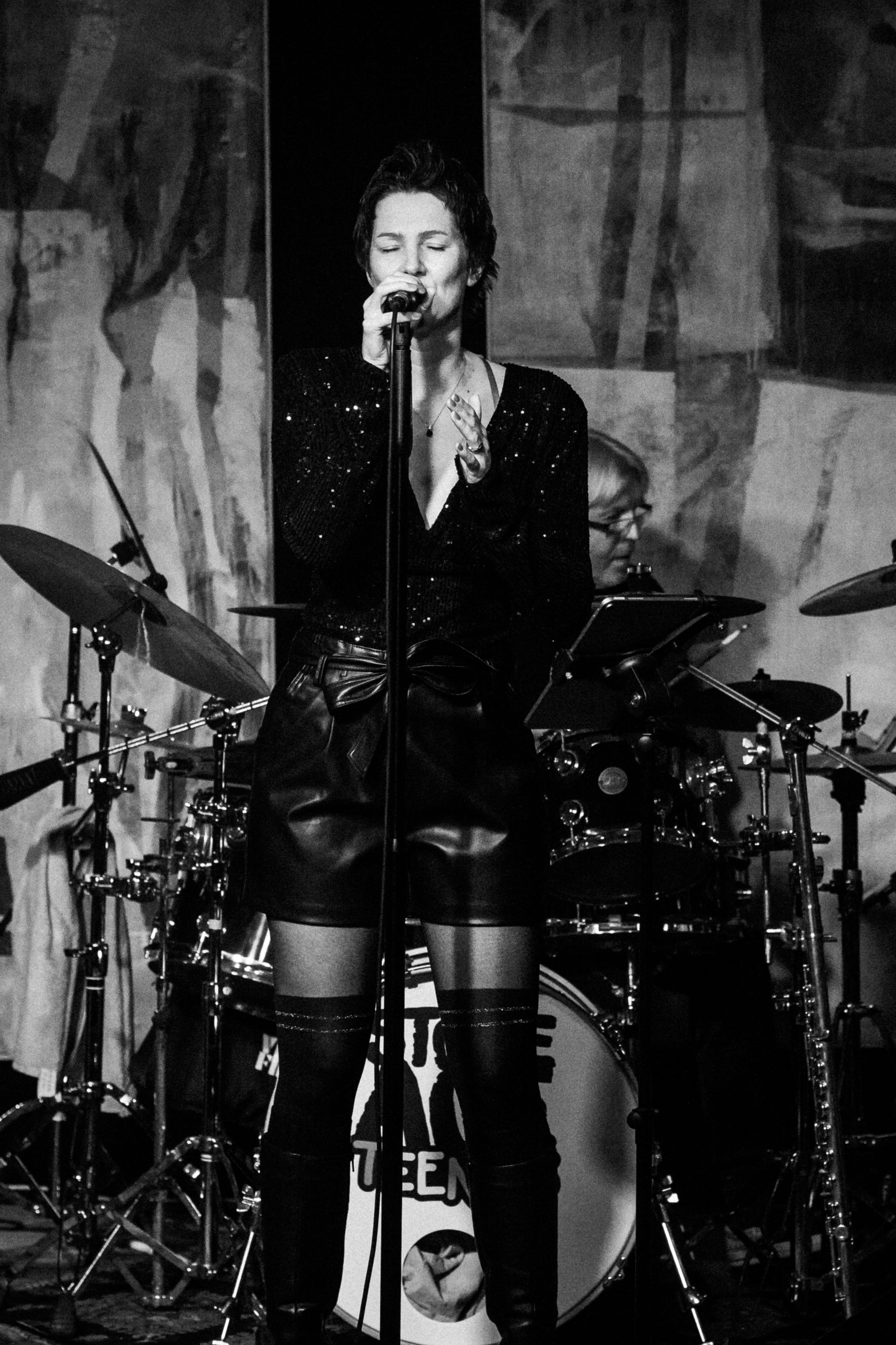 Auf einem Schwarz-Weiß-Foto singt Natalia Salamin in ein Mikrofon.