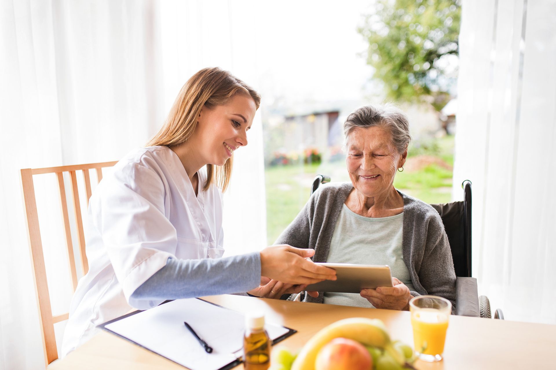 woman in skilled nursing home eating breakfast with female caregiver 