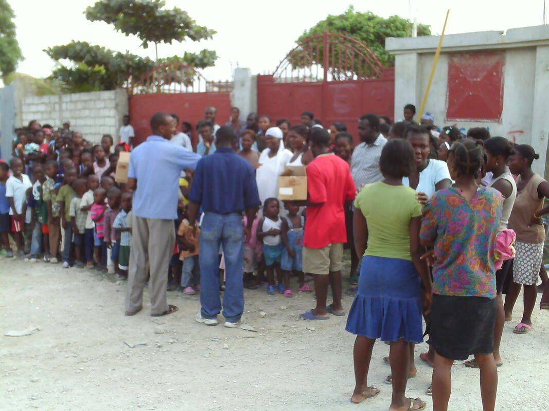 A group of people are standing in a line in front of a red gate