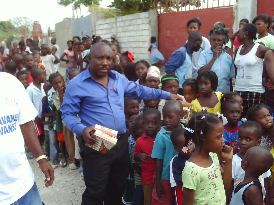 A man in a vans shirt stands in front of a crowd of children