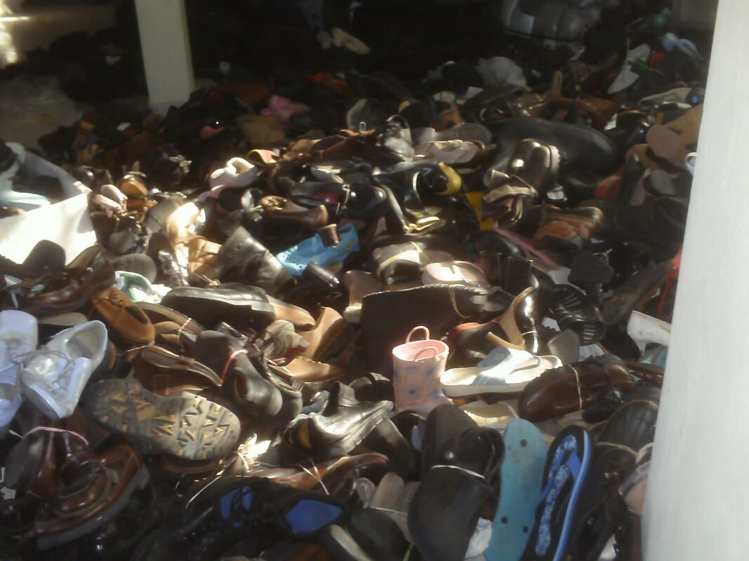 A pile of shoes is sitting on the floor in a room