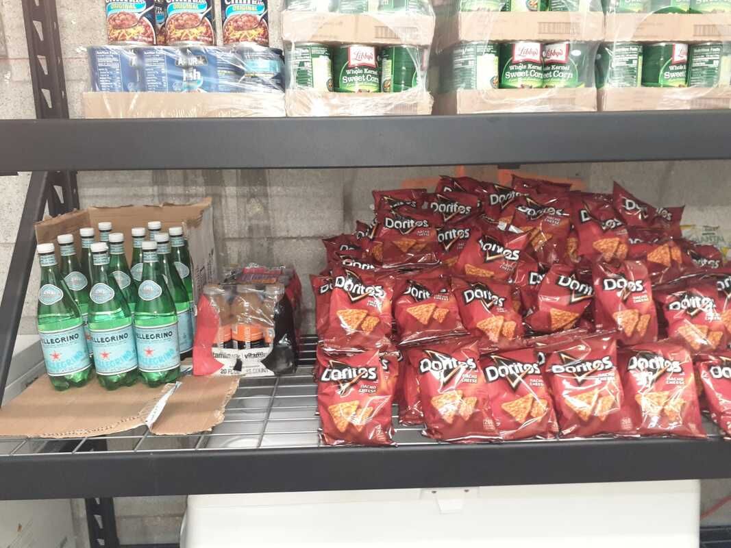 A shelf filled with bags of doritos and bottles of water.