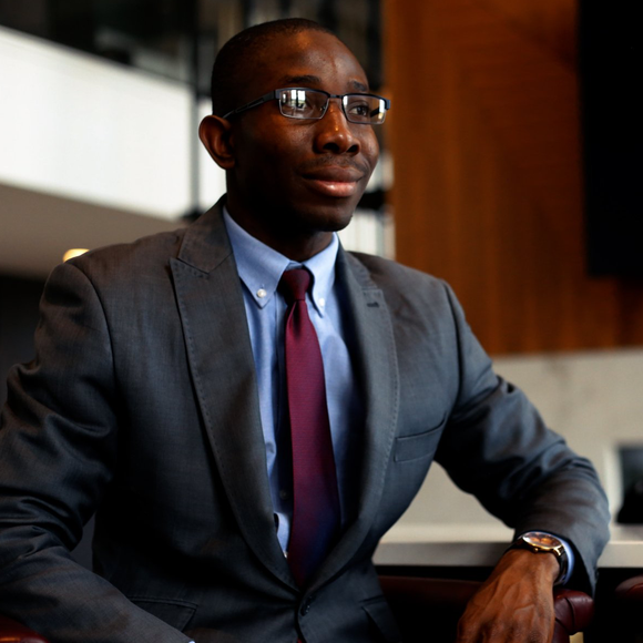 A man in a suit and tie is sitting in a chair