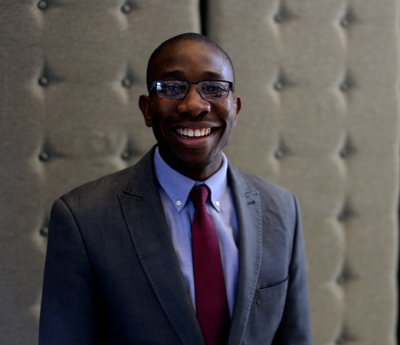A man in a suit and tie is smiling for the camera