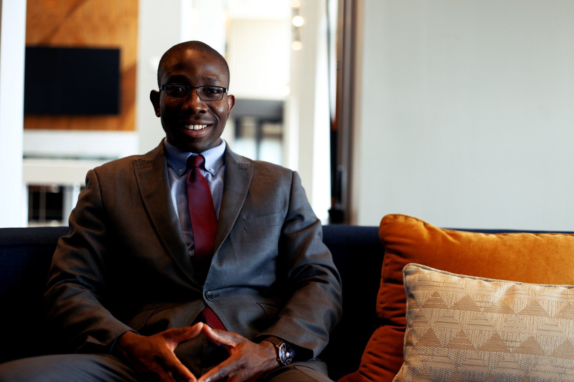 A man in a suit and tie is sitting on a couch.