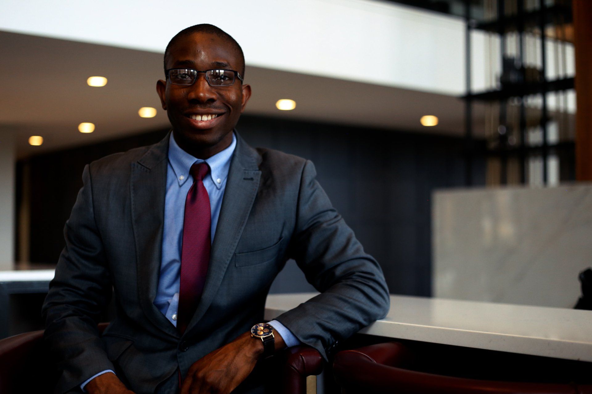 A man in a suit and tie is sitting in a chair.