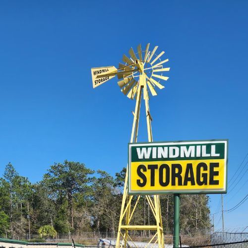 Yellow windmill and sign for Windmill Storage against a blue sky.