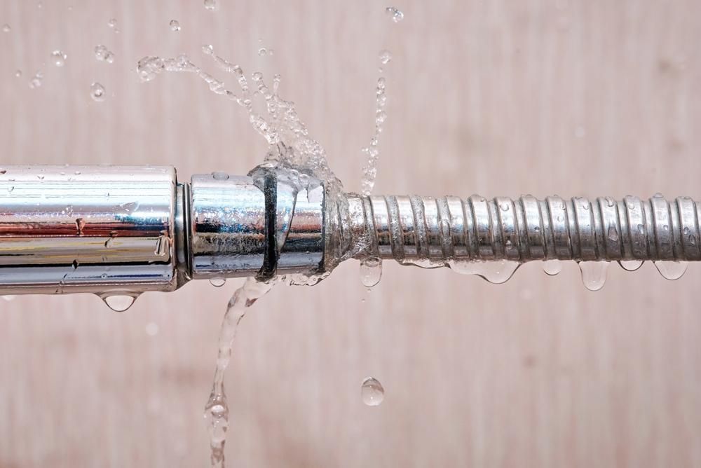 Water spraying from a leaky metal hose connection.
