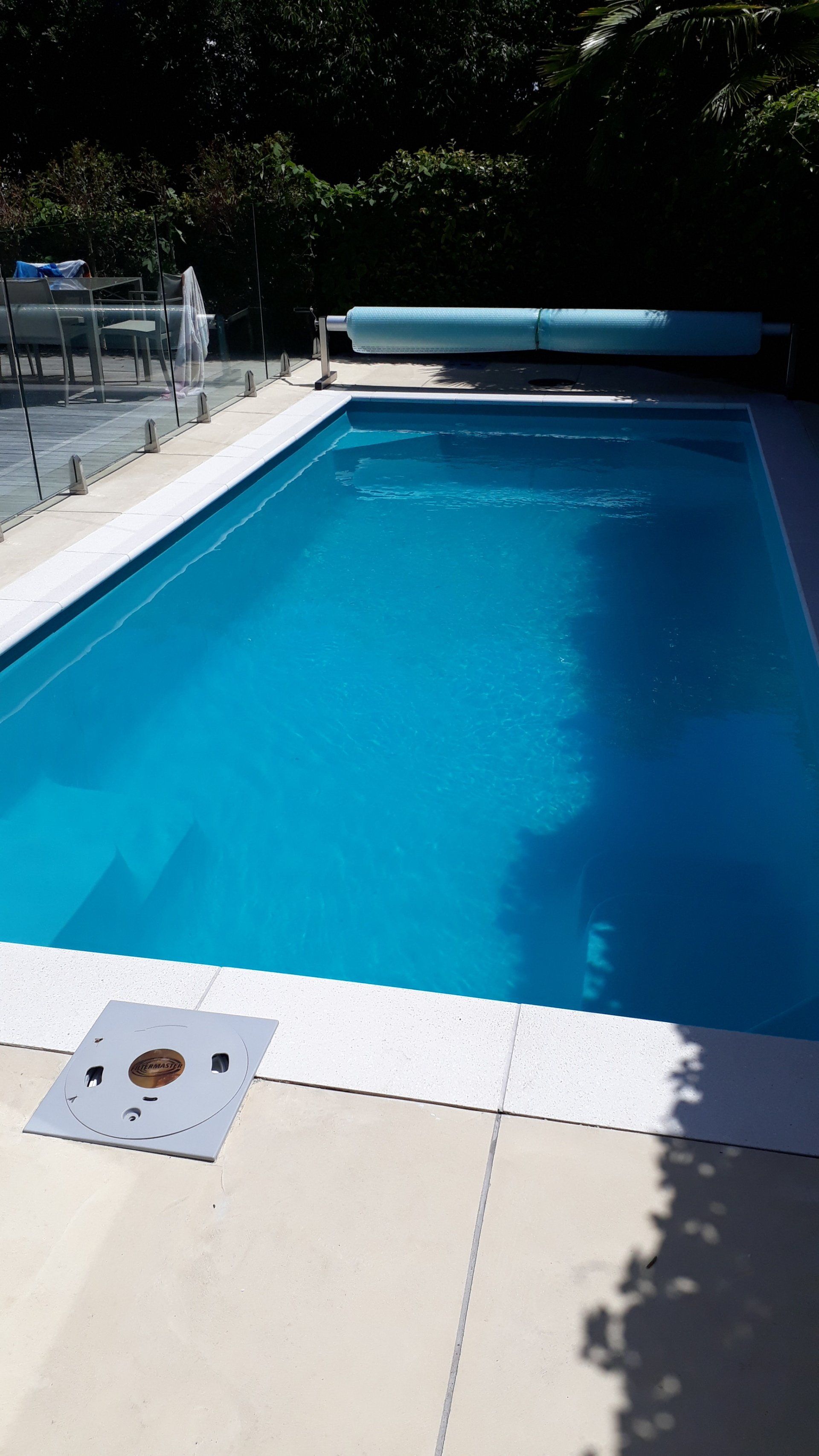 A large blue swimming pool with a white border