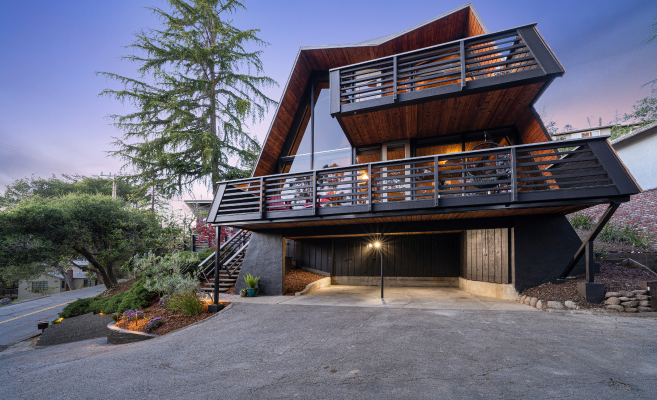 A large house with a lot of windows and balconies is sitting on top of a hill.