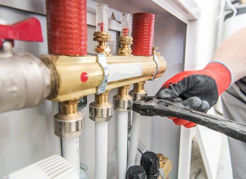 Water Heaters — Plumber Fixing A Pipe System In Staten Island, NY