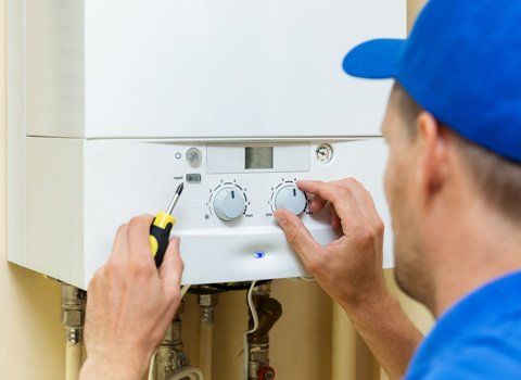 Furnaces — Plumber Fixing A Water Heater In Staten Island, NY