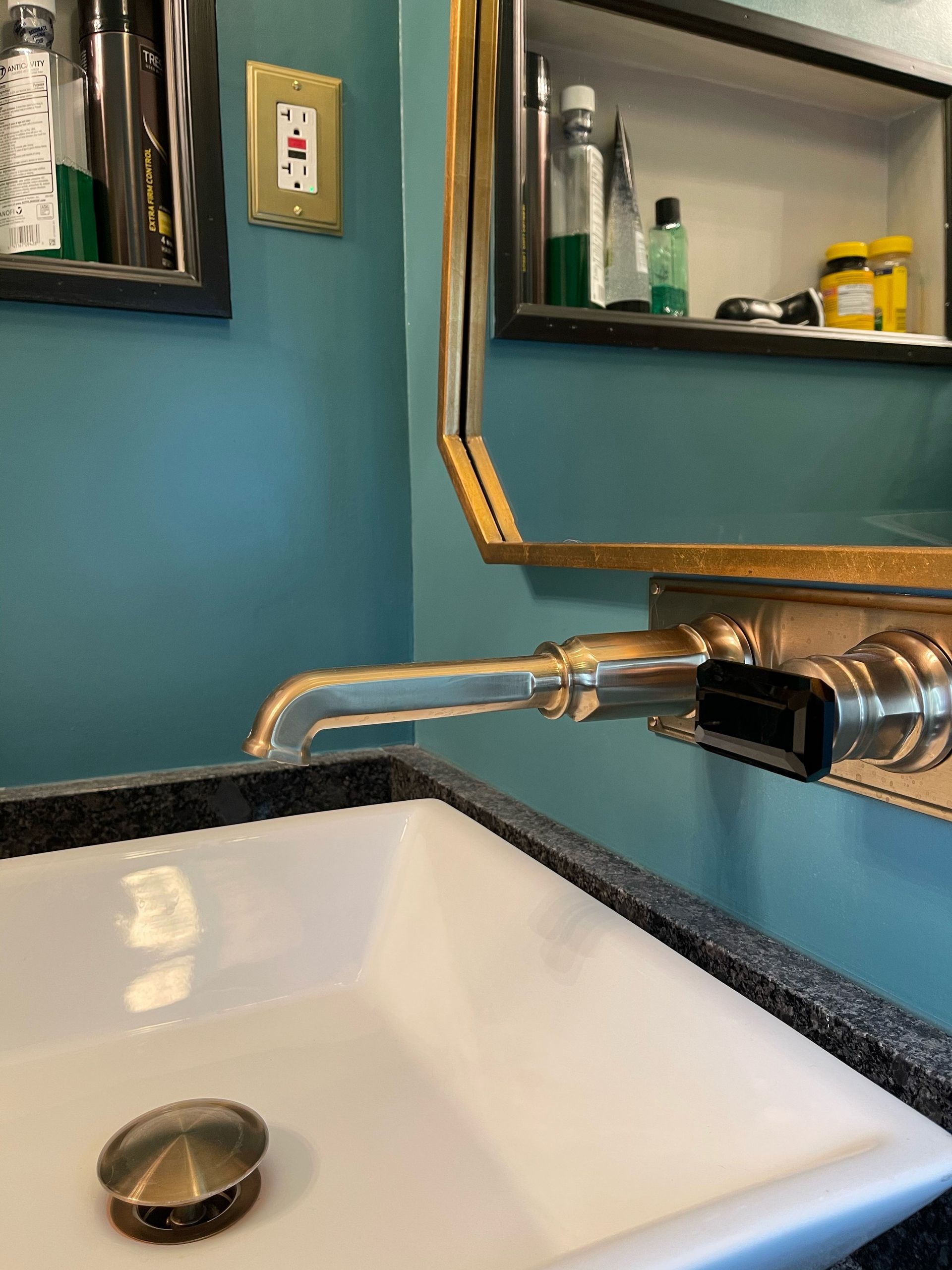 A bathroom sink with a drain and a mirror