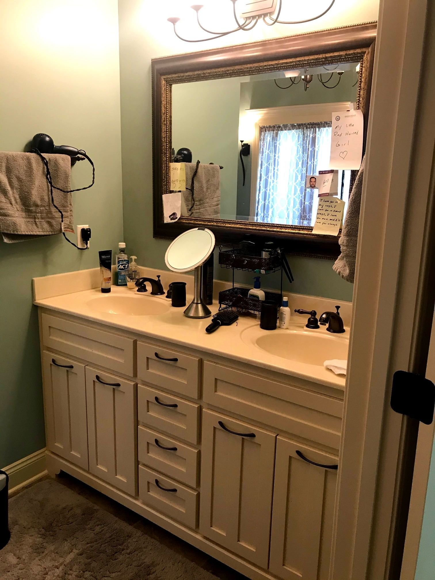 A bathroom with two sinks , a mirror and a hair dryer.