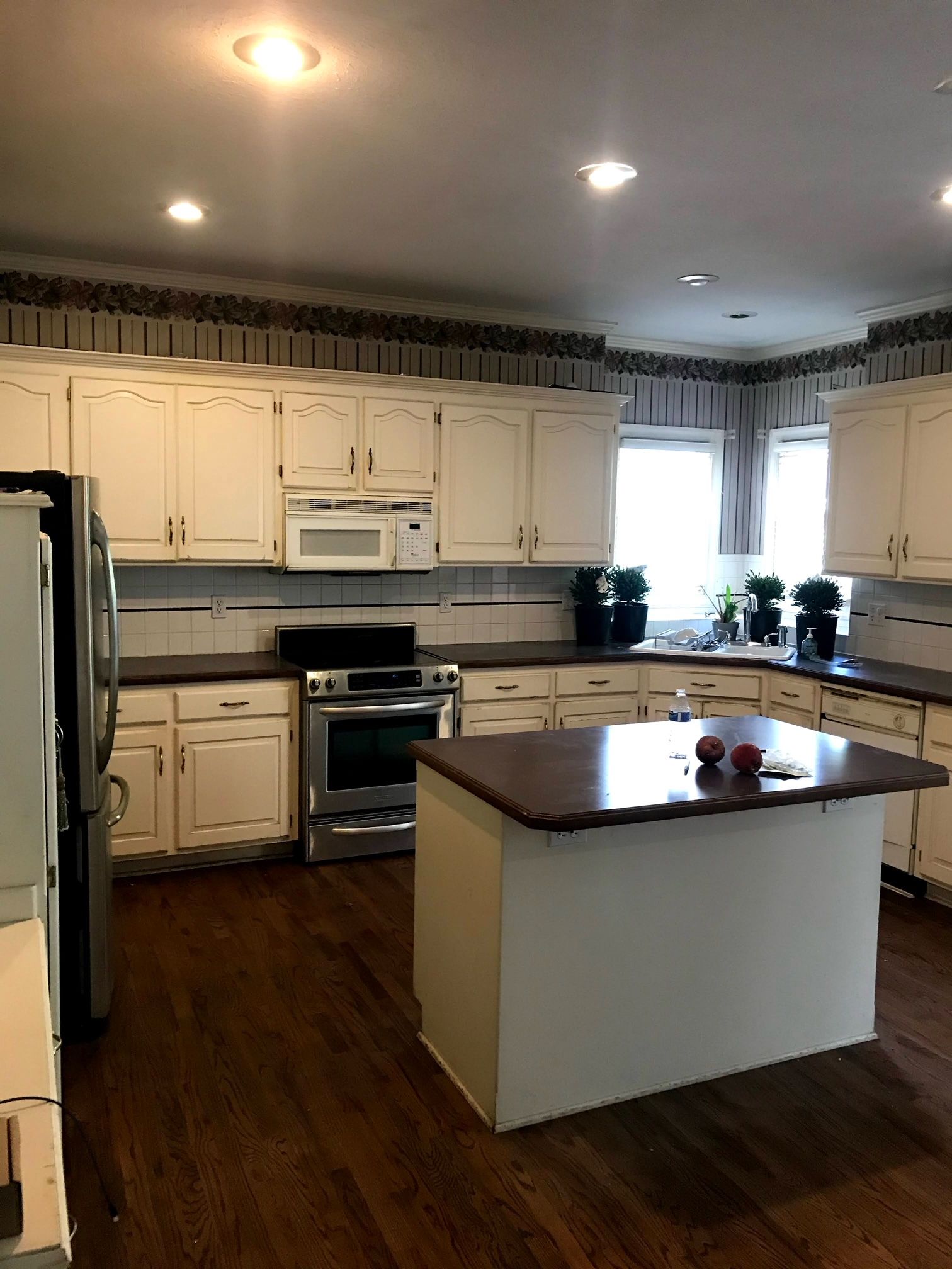 A kitchen with white cabinets and a large island