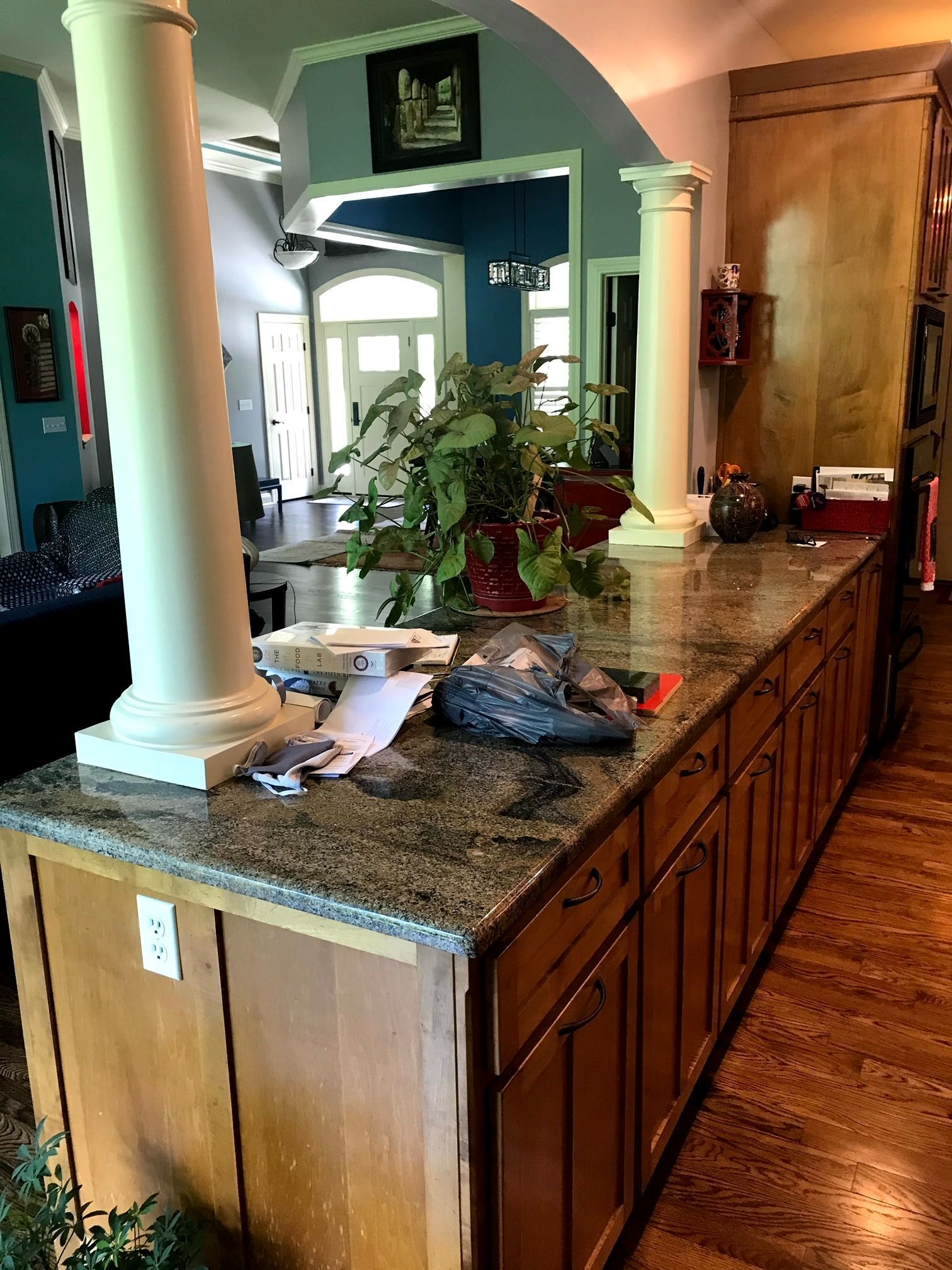 A kitchen with a granite counter top and wooden cabinets.