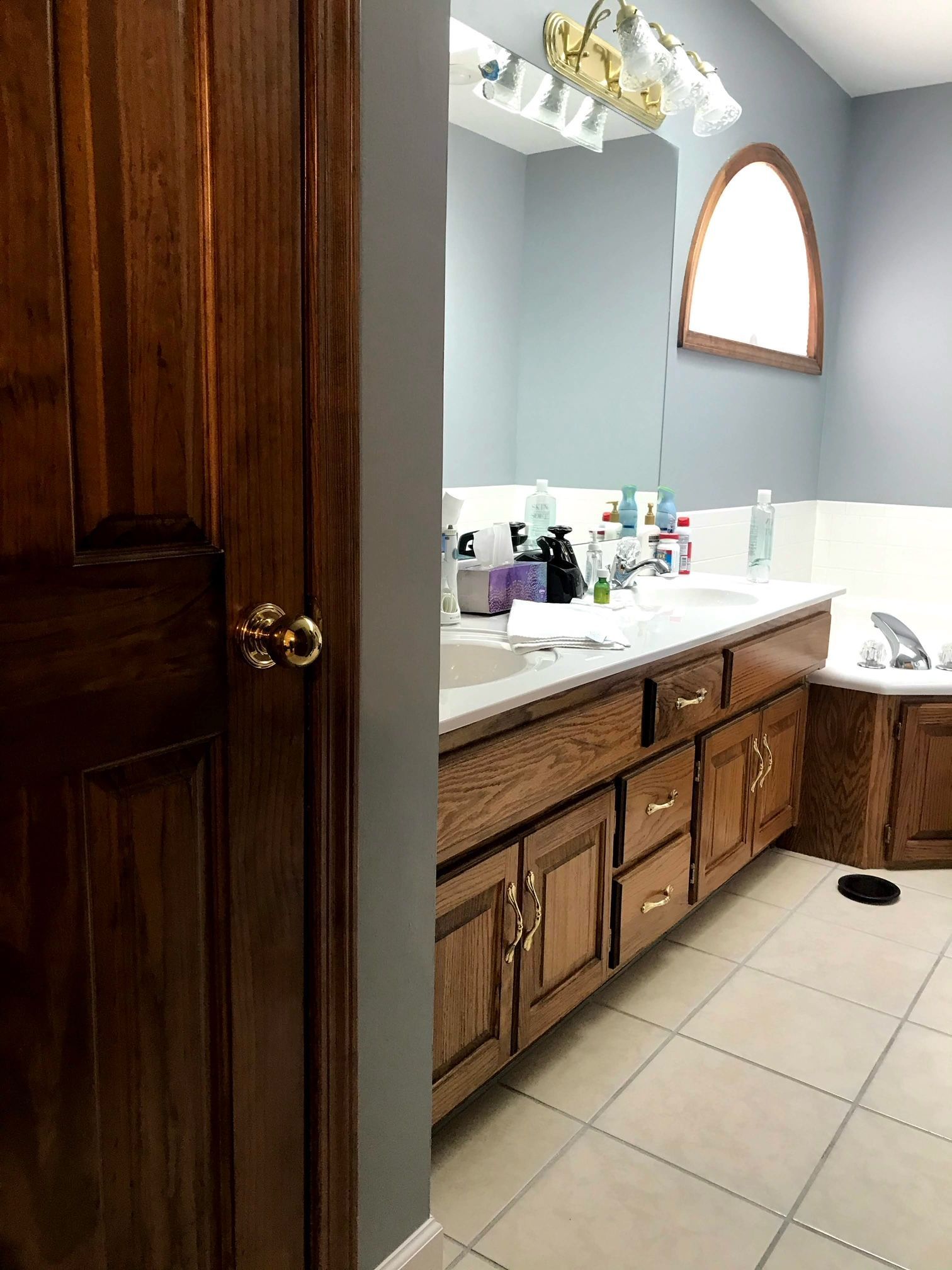 A bathroom with two sinks , a tub and a mirror.