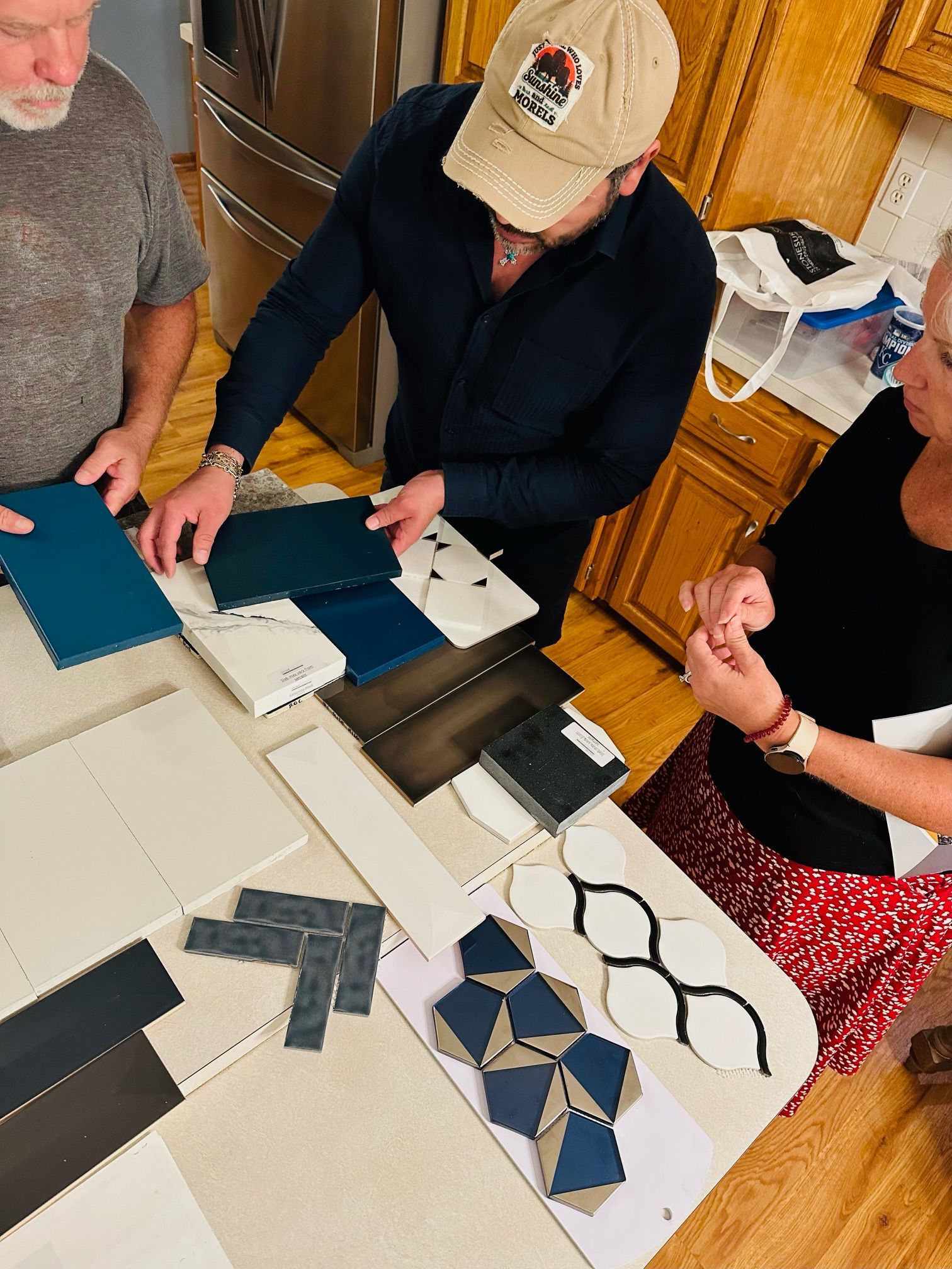 A group of people are sitting around a table looking at tiles.